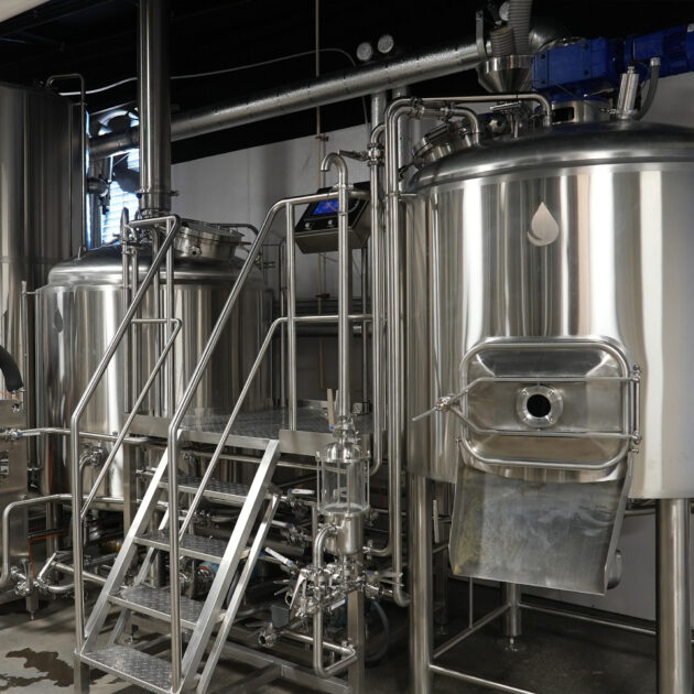 Stainless spirit-side tanks arranged in a finishing and storage area.